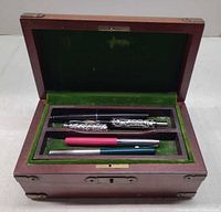 Open box showing four pens in tray