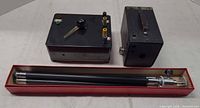 All items: box camera, electronics box, collapsed tripod in red box