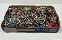 Full view of box showing assorted tangled costume jewellery