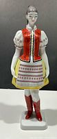 Front view of porcelain woman figurine showing full folk costume details