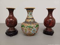 Front view of all three cloisonné vases on stands