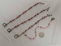 Four pink crystal bead bracelets with quarter for scale