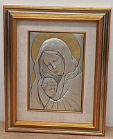 Full view of framed silver bas-relief plaque