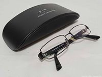 Eyeglasses positioned beside branded hard case