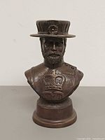 Front view of bronze bust showing facial features and crown insignia