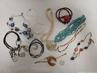 Group shot of all necklaces with quarter for scale