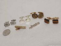 Group shot of all cufflinks, tie clips, brooch