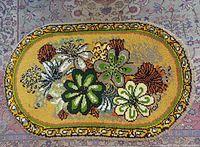 Full view of oval floral wool rug on patterned floor