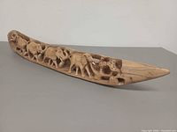 Side view showing full length of hand-carved wooden elephant sculpture