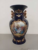 front view showing cobalt glaze, gold gilding, pastoral scene