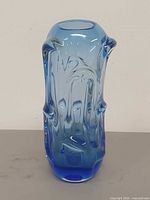 Front view of blue sculptural glass vase