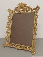 Full front view of ornate brass frame with backing