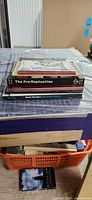 Stack of eight softcover art catalogs on table