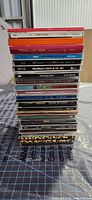 Vertical stack of 18 jewel case CDs showing assorted spine titles