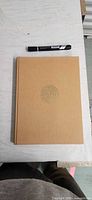 Front cover tan cloth with symbol