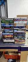 Two tall stacks of assorted DVD cases on cutting mat