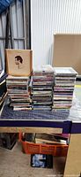 Overall view of two stacks of CDs and wooden sleeve on worktable