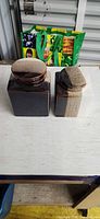 Front view of both square stoneware canisters with lids on