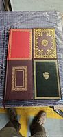 Front covers of all four leatherette books showing decorative gilt work