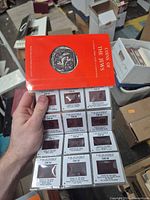 Hand holding booklet and full set of slides