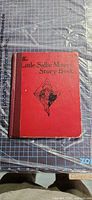 Front cover showing title, illustration, red boards, cloth spine