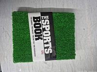Front cover showing artificial turf texture and title band