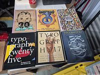 Six hardcover typography annuals laid out on table