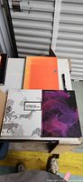 Front covers of both hardcover books on table