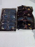 Two boxes of sunglasses side by side