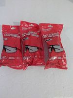 All three sealed packages of Milwaukee gray safety glasses