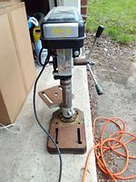 Front view of Brico drill press showing base, column, head, power cord