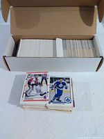 Short box filled with upright hockey cards and two loose stacks in front