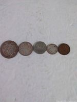 Obverse sides of all five 1950 Canadian coins lined up largest to smallest