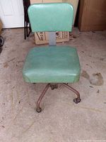 Front view of green vinyl swivel chair