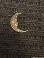 Front of 14k gold crescent moon pendant with face detail