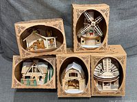 Front view of five boxed Ginger Cottages ornaments showing each design