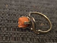 Profile view of ring showing carved orange stone and gold washed sterling setting