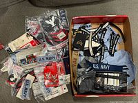 Overall lot view showing bagged badges, name tapes, ribbon sets, box of patches