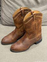 Side view of both boots showing leather condition, shaft embroidery, and heel