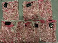 Ten packaged EBZA pink lace skirts with tags visible