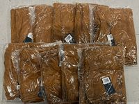 Ten packaged brown lace skirts stacked