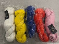 All five skirts in factory-folded plastic packaging showing colour variety