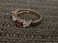 Side view of the sterling silver ring showing red and clear stones