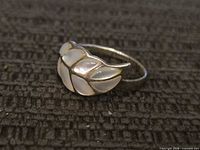 Front view of sterling silver ring showing feather design and shell inlay