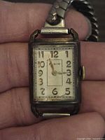Front view of Elgin watch showing dial, numerals, hands, and case wear
