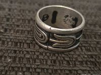 Side view showing raised swirl design and interior hallmark