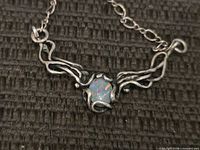 Front view of sterling silver necklace showing opal and vine design