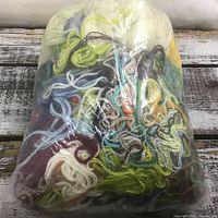 Front view of bag showing mixed coloured yarn/thread skeins