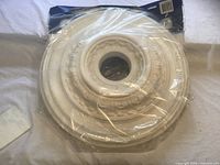 Front view of sealed Balmer VI ceiling medallion showing ornate design through plastic