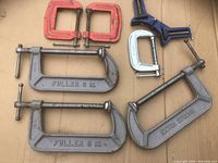 Group shot of all seven C clamps on cardboard